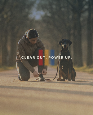 A girl and a dog about to go for a run outside.