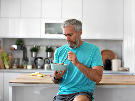 A man eating in his kitchen.